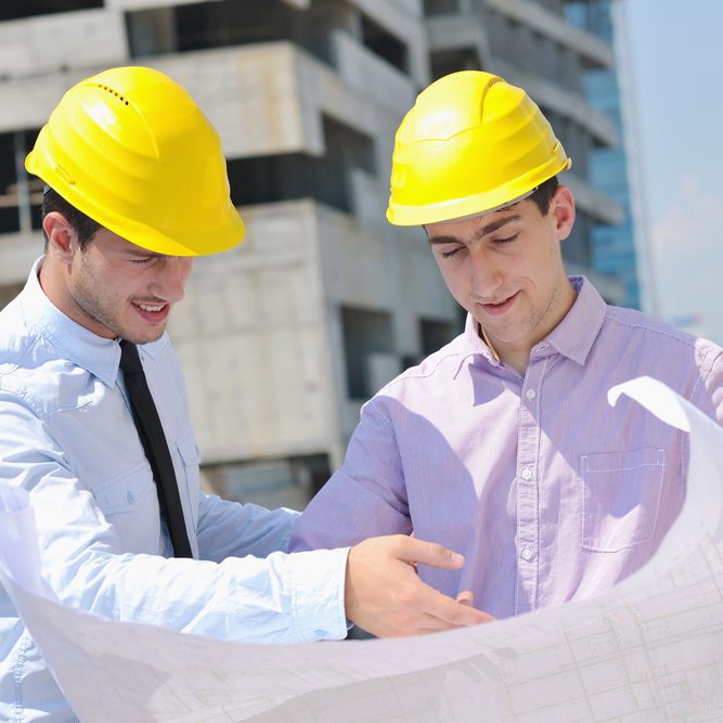 Ingenieure mit gelbem Helm besprechen einen Plan